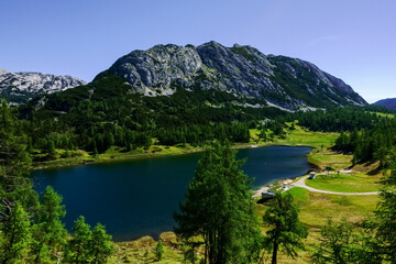 Fototapeta na wymiar deep blue lake in a green landscape with mountains