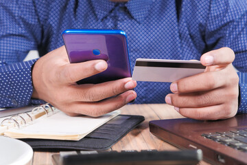 Man hand holding credit card and using smart phone shopping online 