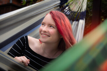 Fototapeta na wymiar woman with red hair, smiling, in a hammock
