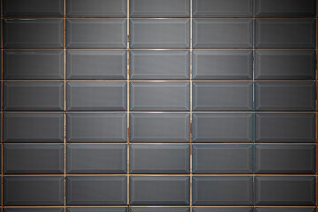 Gray or black, glossy ceramic floor tile brick wall texture background.
