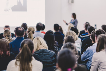 Business and entrepreneurship symposium. Female speaker giving a talk at business meeting. Audience...