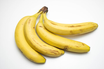 four ripe and yellow bananas lie on a white background