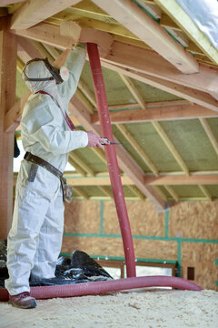 carpenter projecting insulation into a roof