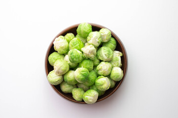green Brussels sprouts its leaves lie on the table and in a wooden bowl