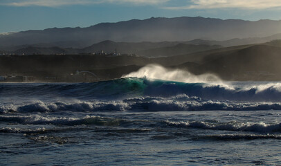 Powerful foamy ocean waves waves are breaking along Las Canteras and El Confital town beaches in Las Palmas de Gran Canaria
