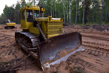 Dozer during clearing forest for construction new road . Yellow Bulldozer at forestry work...