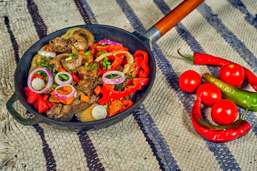 Fried poultry liver with vegetables in a pan at home . Cooking at home