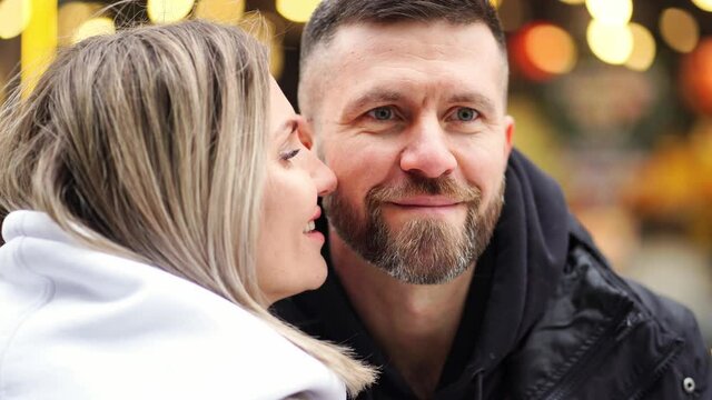 close-up. man and woman pose for winter photo shoot in street amid lights. bokeh