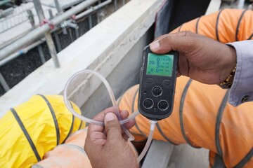 Construction supervisor hand holding gas detector device while commencing safety gas testing...