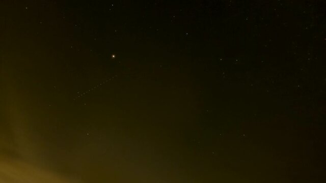 Stars seem to scroll by as the Earth rotates and and wispy clouds blow by in this all night time lapse