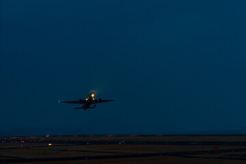 夕暮れの空港を離陸する航空機