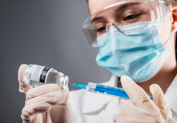 Doctor holding a syringe with a single bottle vial of Covid-19 vaccine for children or adults....