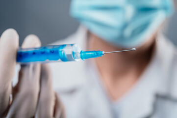 Doctor holding a syringe with a single bottle vial of Covid-19 vaccine for children or adults....