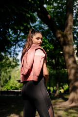 Young woman is resting after jogging in the park.