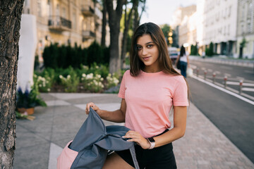 Young woman with open backpack on the street