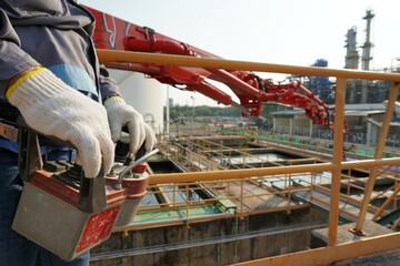 Construction worker control a pouring concrete pump on construction site.