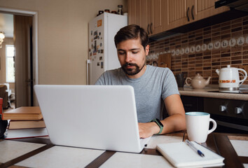 young man freelancer using laptop studying online or working