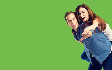 Love, relationship, dating, lovers, romantic concept - happy excited couple, in piggyback pose, over green background.