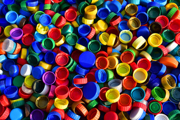 Plastic bottle caps background. Cap material is recyclable.Remove lids from plastic bottles before recycling them. Recycling collection and processing plastic bottle caps