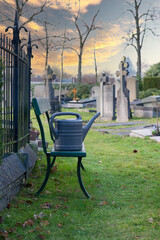 eine Gießkanne steht auf einer Bank