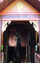 Fototapeta na wymiar standing buddha statue stupa in asian wooden buddhist temple