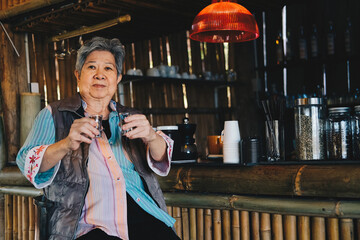 asian old elder woman elderly holding roasted coffee bean in cafe shop