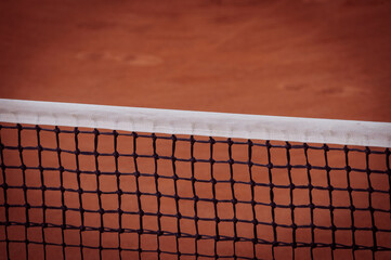 Tennis net with bokeh sand in the background.