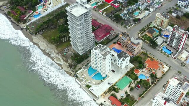 Aerial view; flying along the beach; lined with expensive hotels; swimming pools and tennis courts