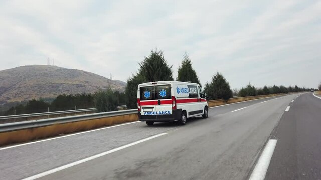 Corrona emergency patient is transported with ambulance van driving fast on highway road