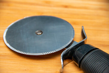 Pizza cutter on a wooden cutting board