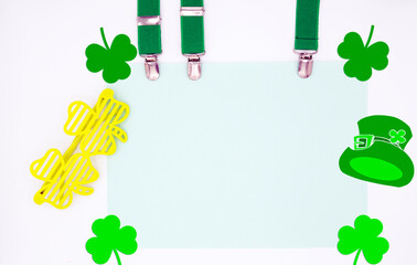 Visuel pour la Saint Patrick avec espace pour votre slogan, trèfles lunettes bretelles et chapeau en décoration. Disposition à plat, vue de dessus