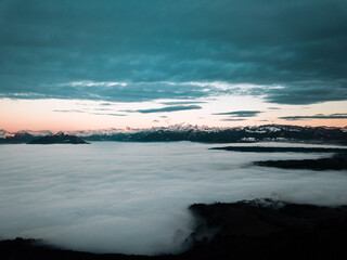 Montagnes enneigées au dessus d'une mer de nuages.