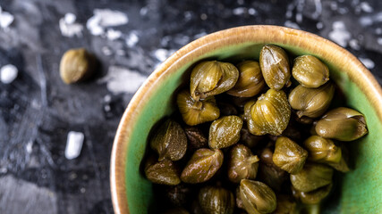 Pickled or marinated green capers close-up, Delicious ingredients for cooking Mediterranean, Italian, Spanish, French cuisine. top view