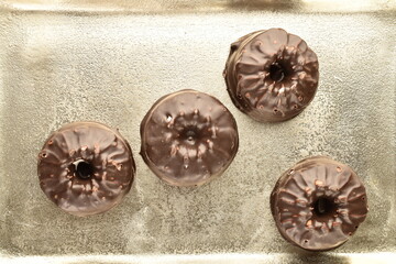Several sweet chocolate marshmallows on a metal tray, close-up.