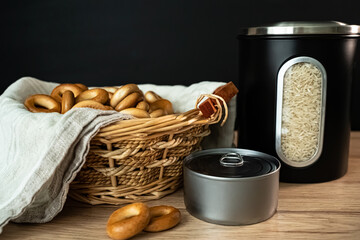 Products that have the long shelf life. On the table: sweet bagels, rice, canned food.