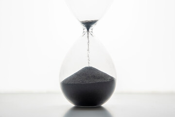 Hourglass on a light background. Time is money. Business solutions in time.