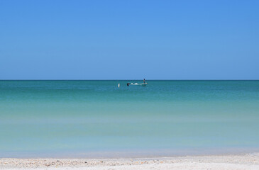 Fototapeta na wymiar Blue green ocean from sand with boat and blue sky
