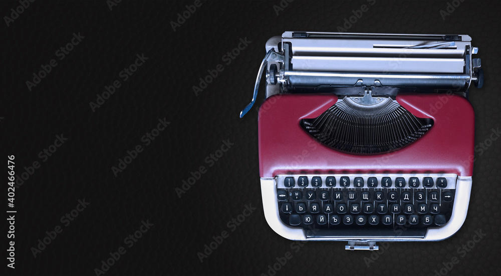 Aufkleber mechanical typewriter on the right against a horizontal dark gray background. red metallic type mach