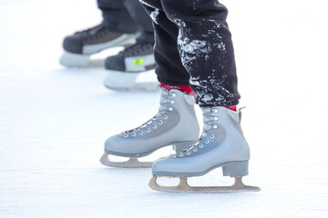 feet on the skates of a person rolling on the ice rink