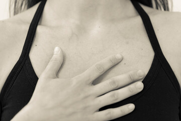BW horizontal detail of chest and shoulders of yogini wearing black one strap yoga top, with open...