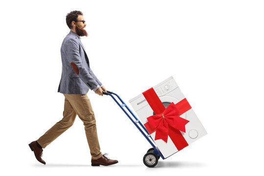 Full length profile shot of a man pushing a hand truck with a washing machine tied with a red ribbon bow
