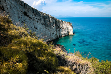 view of the coast on the Greek island of Zakynthos. The sea is clear blue and the sky blue with white clouds.