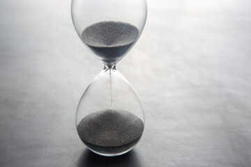 Hourglass on a light background. Time is money. Business solutions in time.