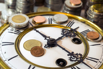 Obraz na płótnie Canvas stack of coins on vintage clock