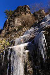 Blue Ridge Parkway – Icicles hanging from cliff wall with trees and bushes above