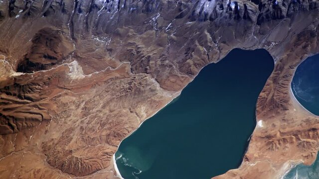 Lake and rock mountains aerial satellite view, Tibet China natural landscape sunrise animation. Images furnished by Nasa