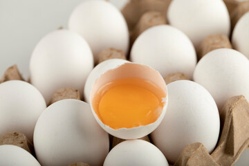 Raw chicken eggs in egg box on a white background