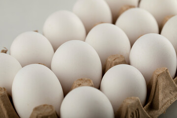 Raw chicken eggs in egg box on a white background