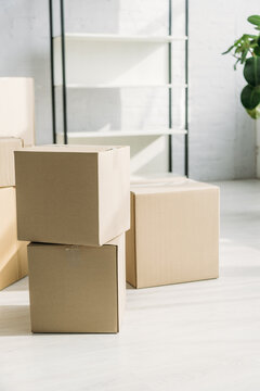 stack of carton boxes near rack on blurred background