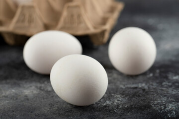 Three raw chicken fresh eggs on a marble background